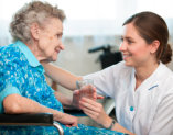 elder woman and her caregiver smiling to each other