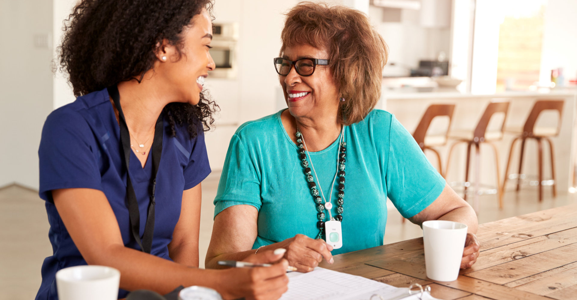 elder woman and her caregiver smiling