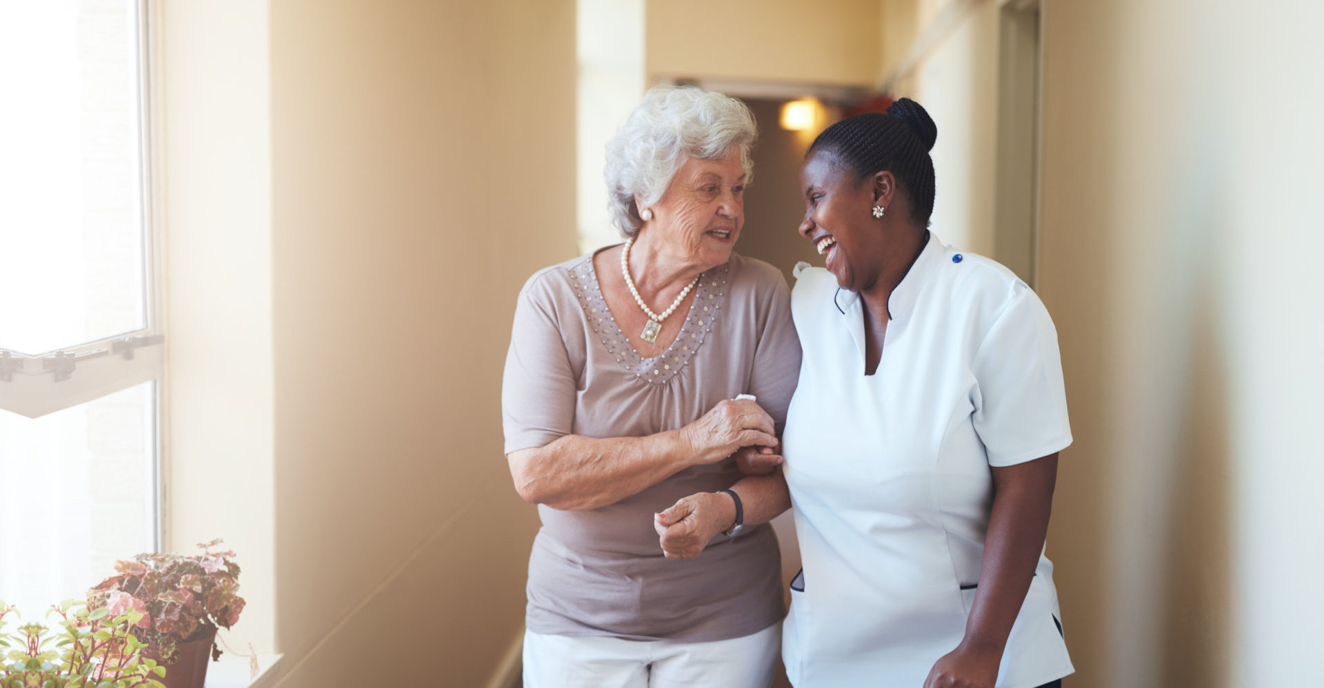 caregiver assisting the elder woman walking