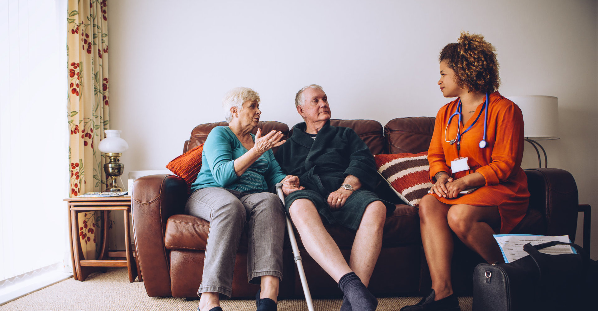 Elderly couple talking to their healthcare worker at home