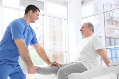 Physiotherapist working with elderly patient in clinic.